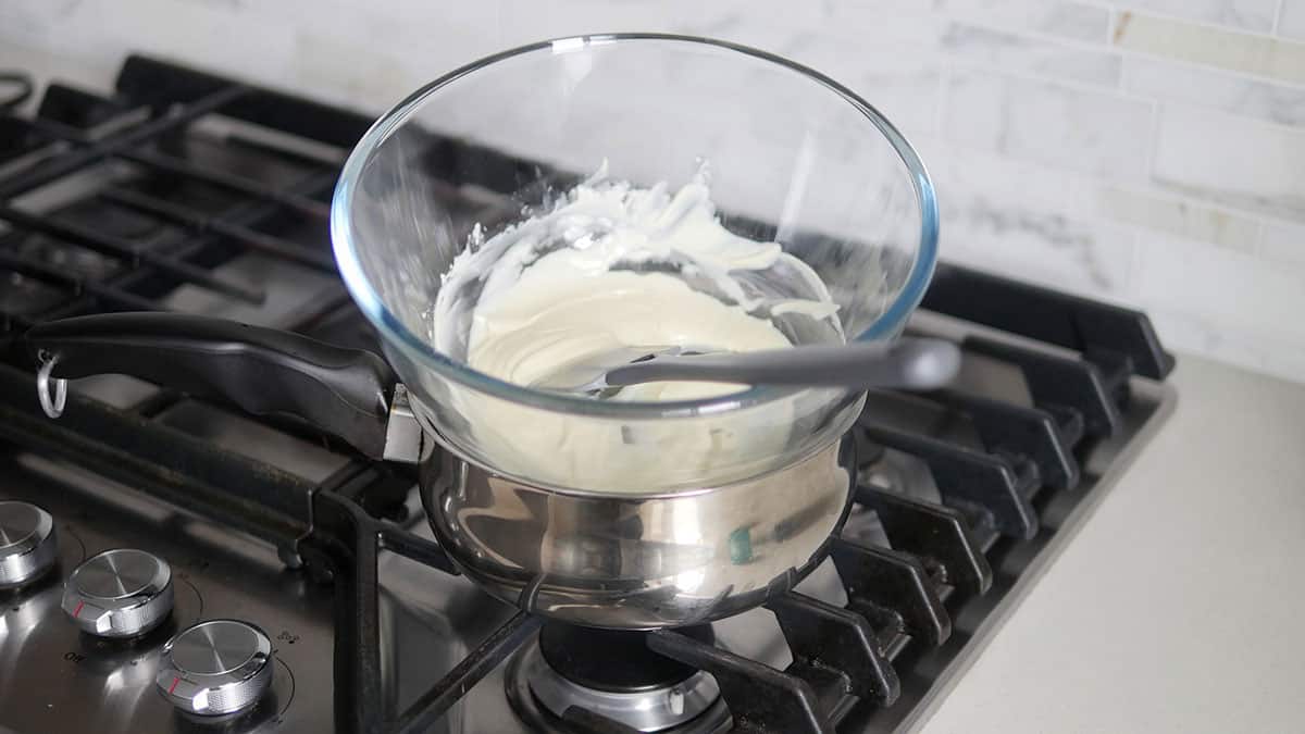 White chocolate has now melted inside the mixing bowl perched over top a pot of hot water. 