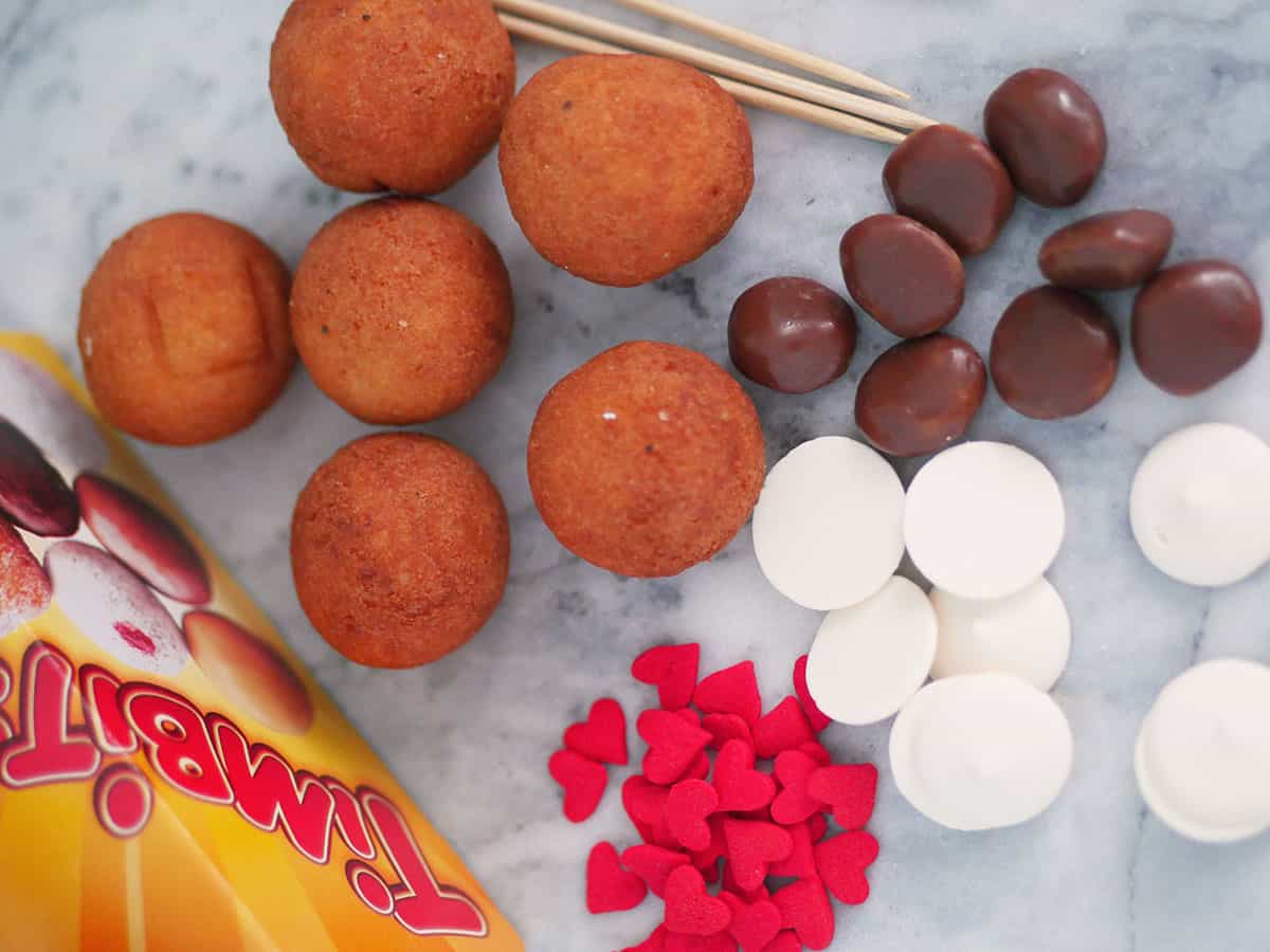 Donut cake pops ingredients on a marble counter surface. 