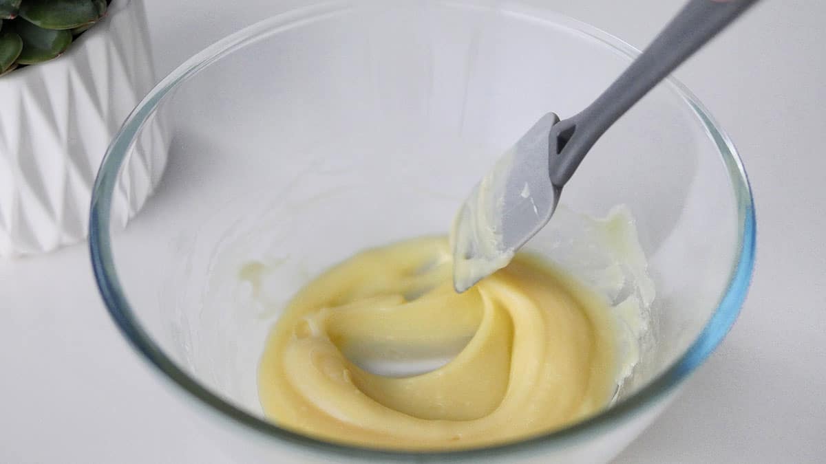 White chocolate macaron filling is now a thick consistency inside a mixing bowl. 