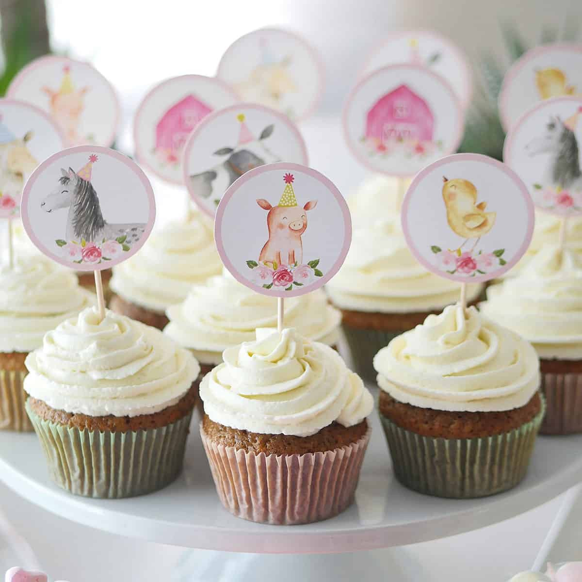 Carrot cupcakes on a cake stand topped with birthday toppers.