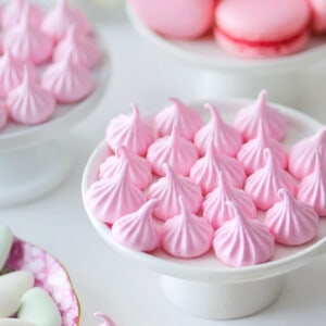 Pink meringue candy kisses on a small cupcake stand.