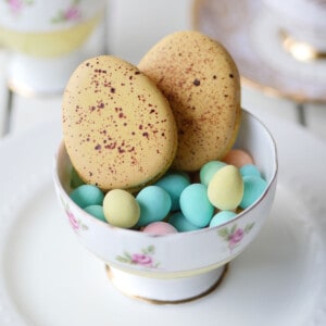 2 large speckled Easter egg macarons in a dish.