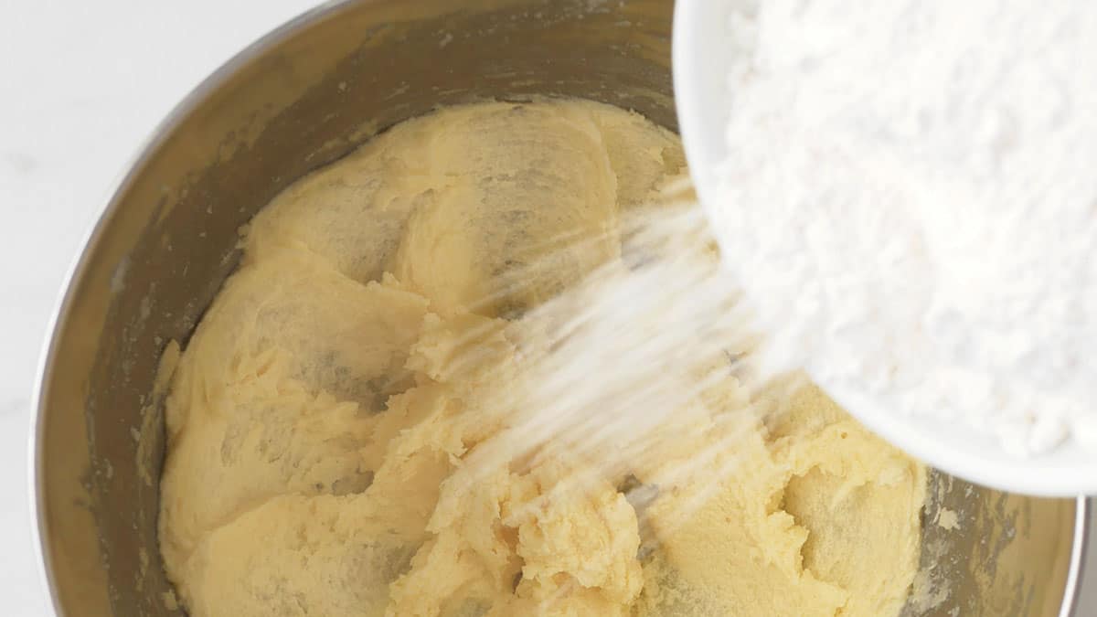 Flour is being added to wet cookie batter. 