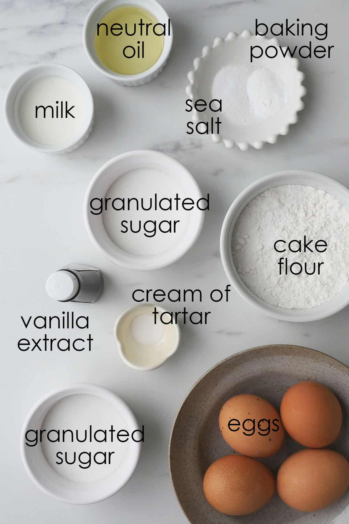 Ingredients for a chiffon cake laid out on a marble counter. 