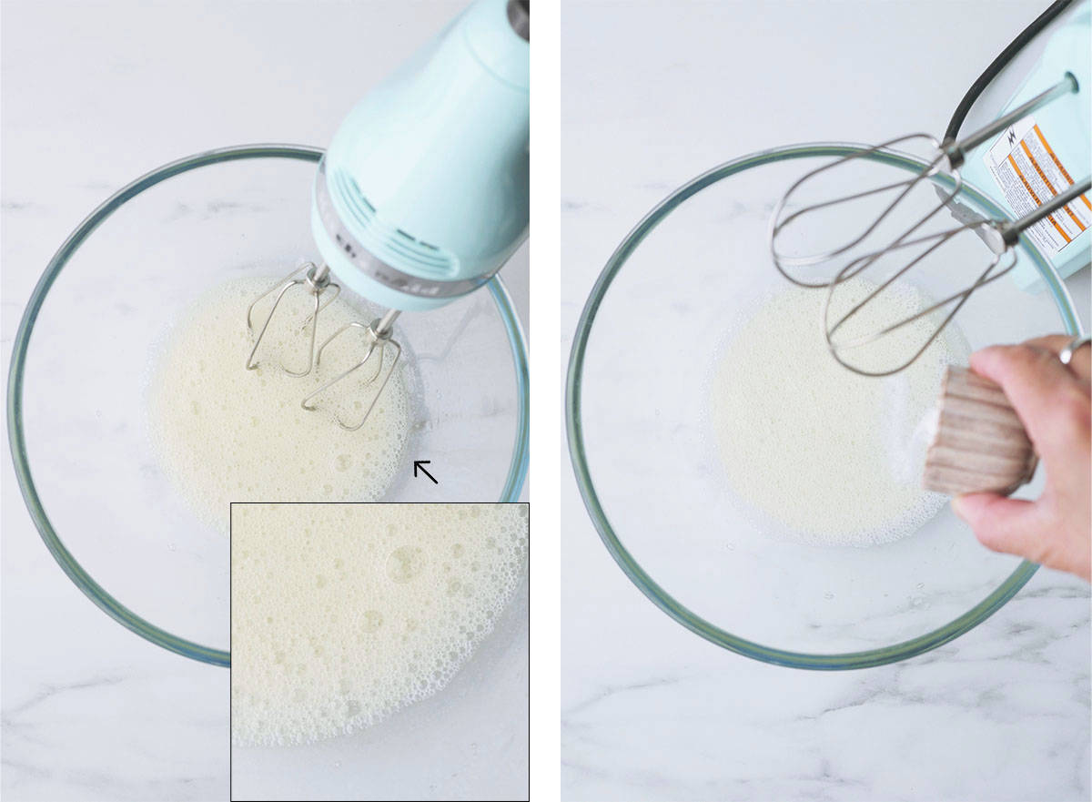 A handheld mixer in a bowl of whipped  egg whites that have large foamy bubbles inside. In the next photo, cream of tartar is being poured into the bowl. 