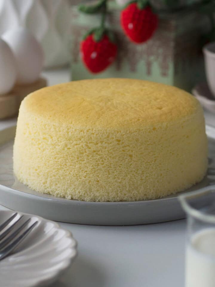 Side profile of Japanese cheesecake showing its smooth outer edge and part of it's golden top.