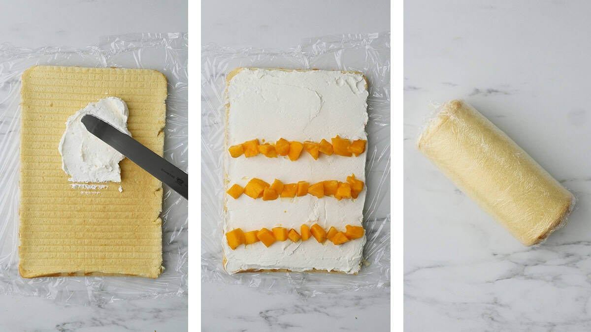 The sheet cake is on the counter while cream is being spread on top and fresh mangos are placed on top of the cream. 