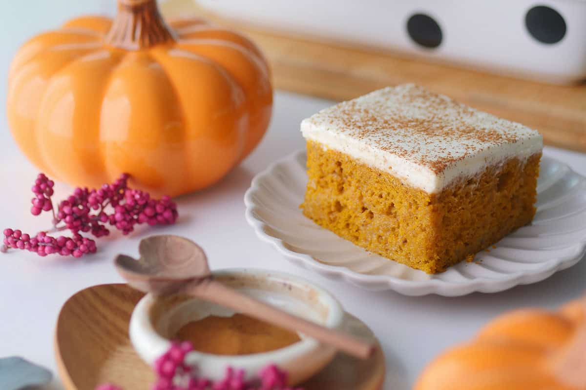 Close up of a slice of pumpkin cake showing the characteristics of Tres Leches style cake with a moist cake body. 