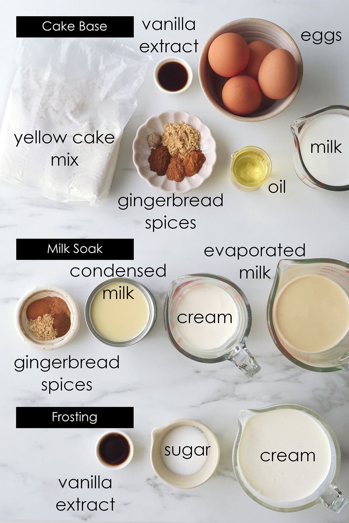 Ingredients for gingerbread spice tres leches cake laid out on a marbled counter.