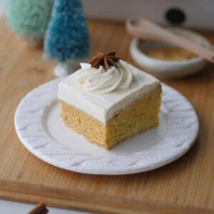 Close up shot of a square slice of gingerbread tres leches dessert on a Christmas braided dessert plate.