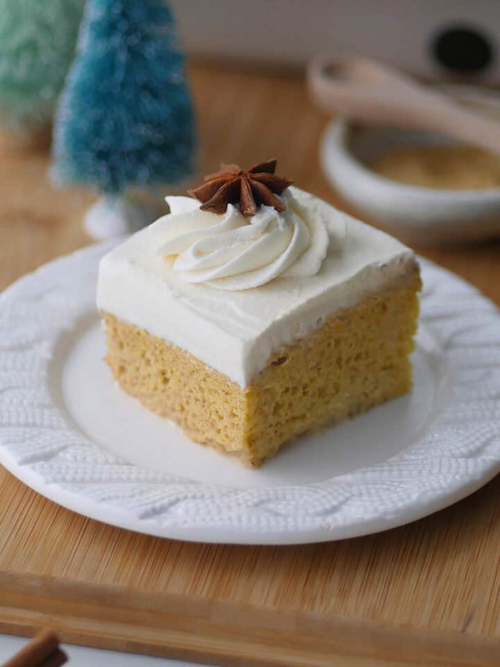 Close up shot of a square slice of gingerbread tres leches dessert on a Christmas braided dessert plate.